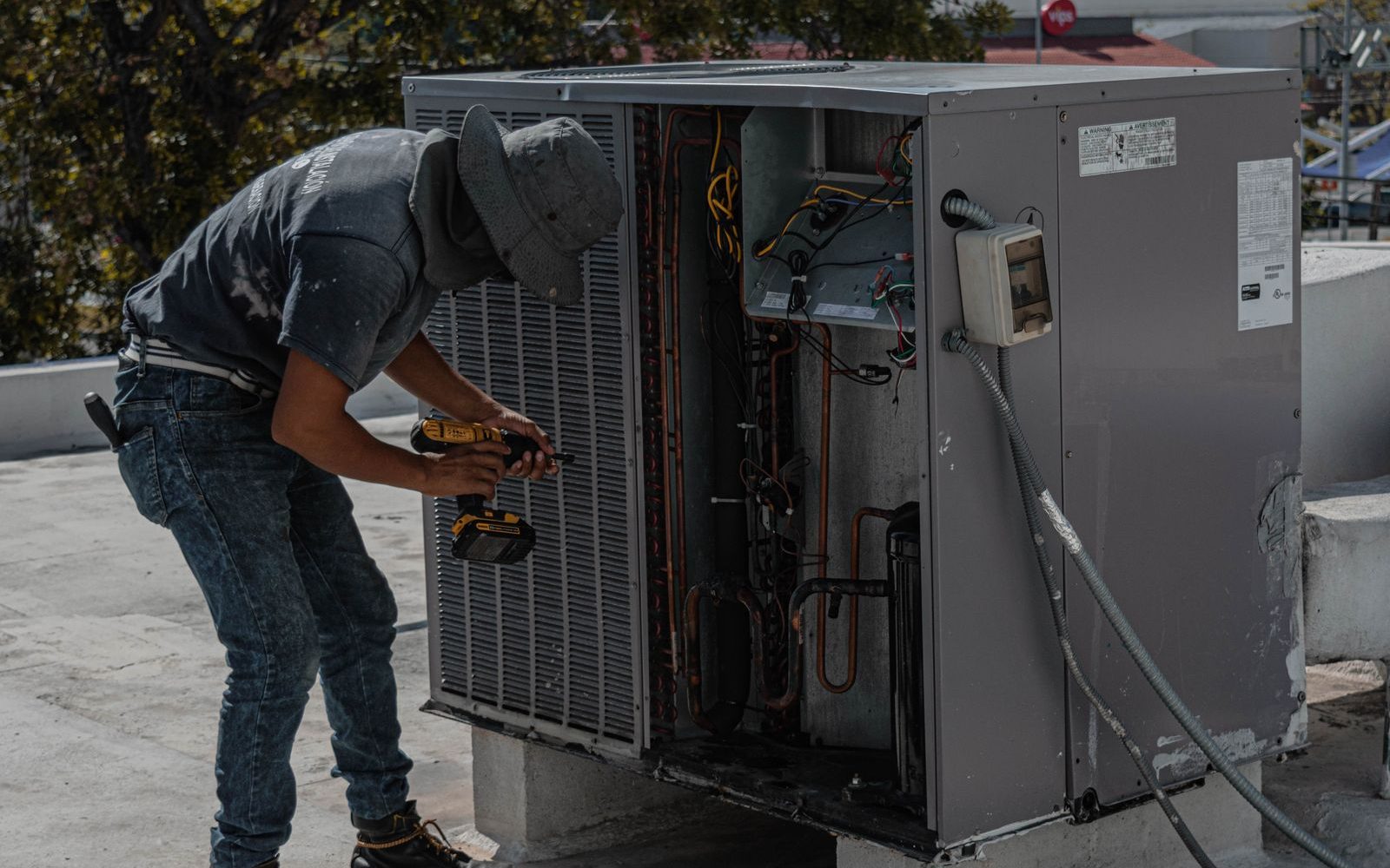 HVAC technician servicing an outdoor air conditioning unit