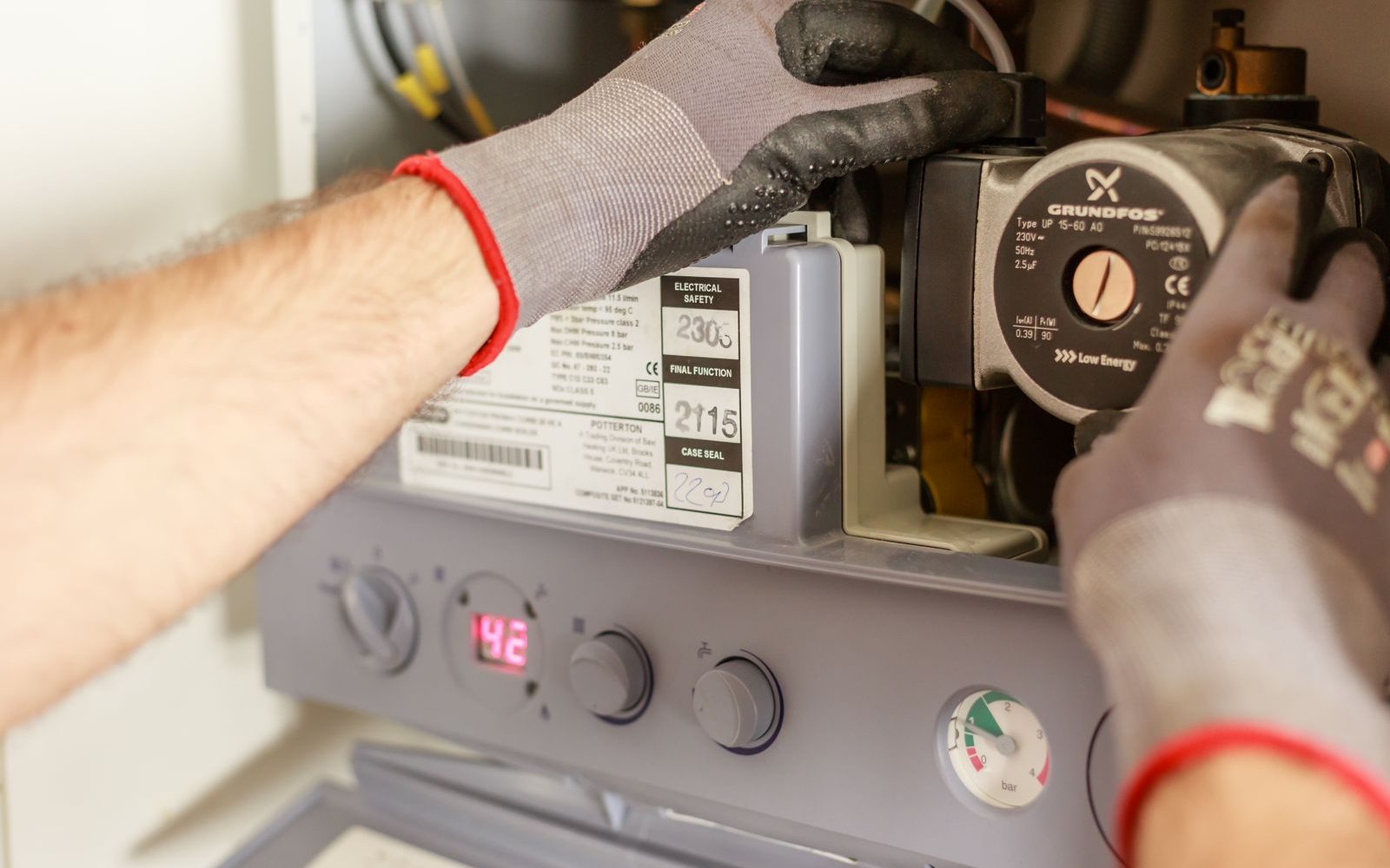 Plumber servicing a home heating system pump
