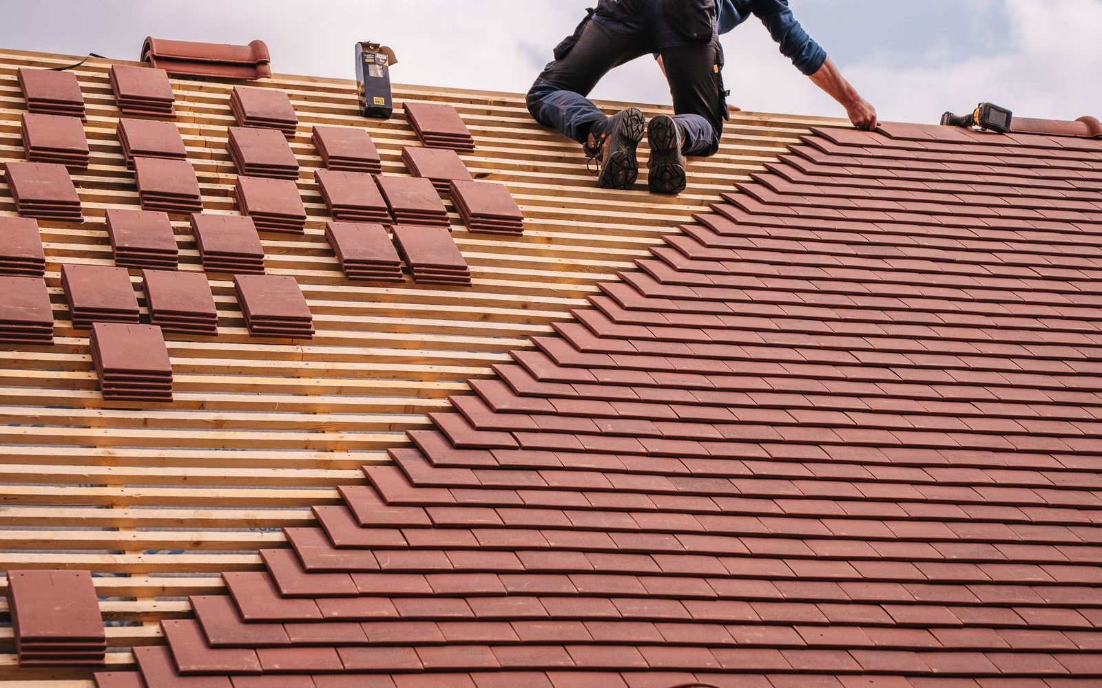 Roofer installing shingles on a residential roof